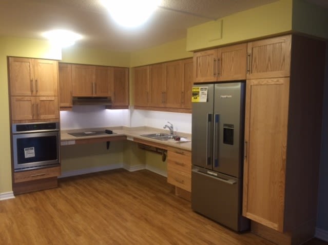 An accessible kitchen with lowered appliances, countertops, wide floor space. 