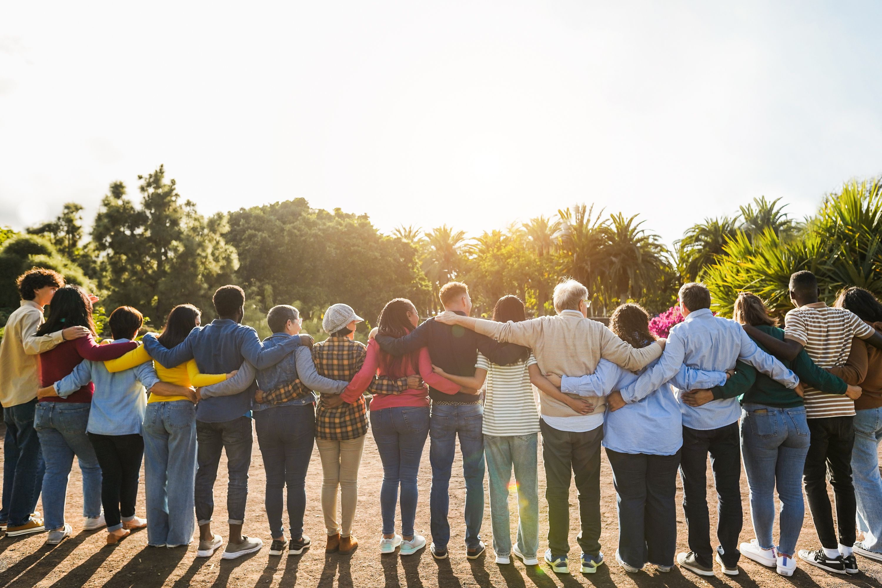 A group of people standing in a line with arms around each other's shoulders.