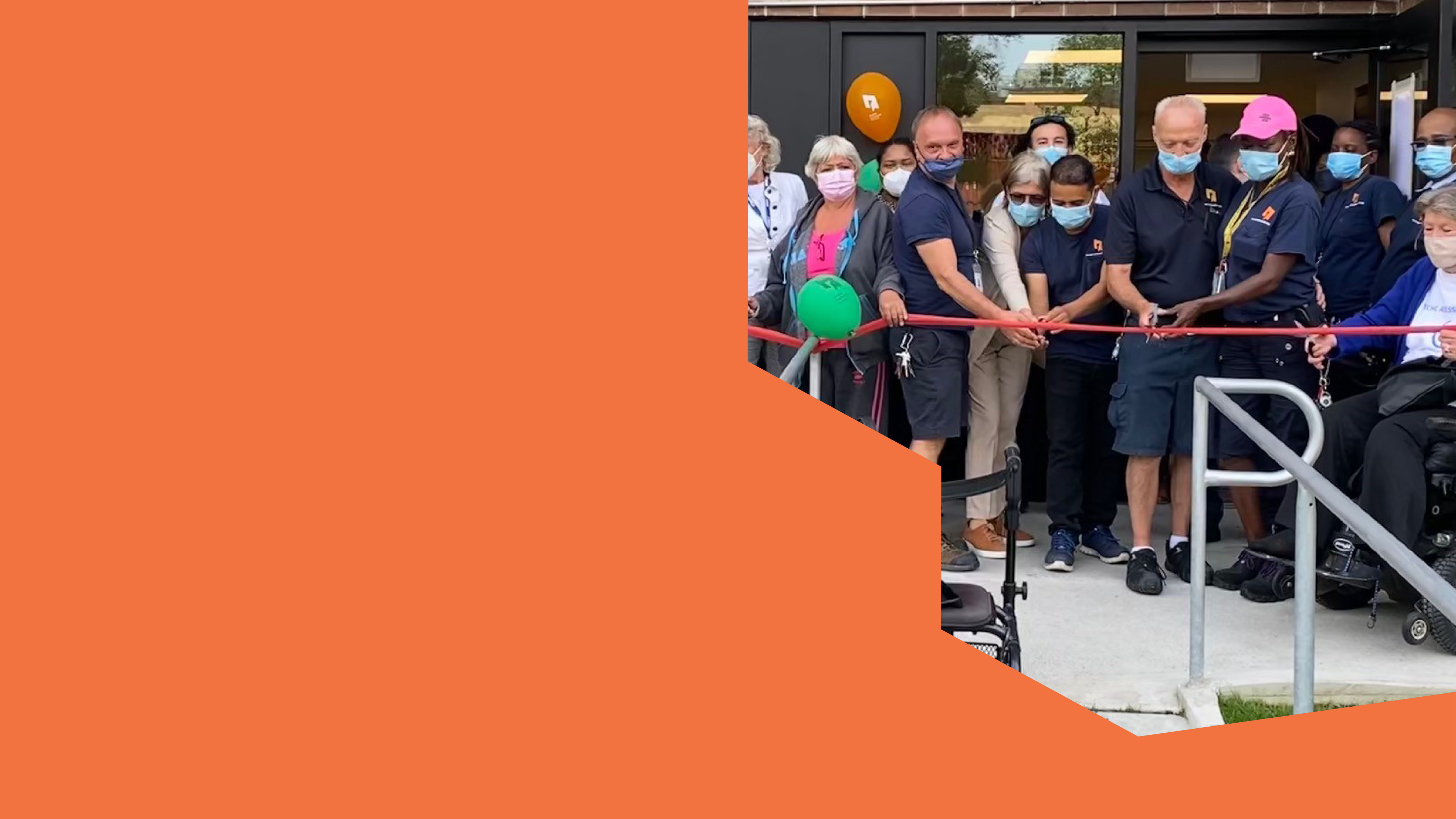 A group of people cutting a ribbon in front of a Tenant Service Hub.