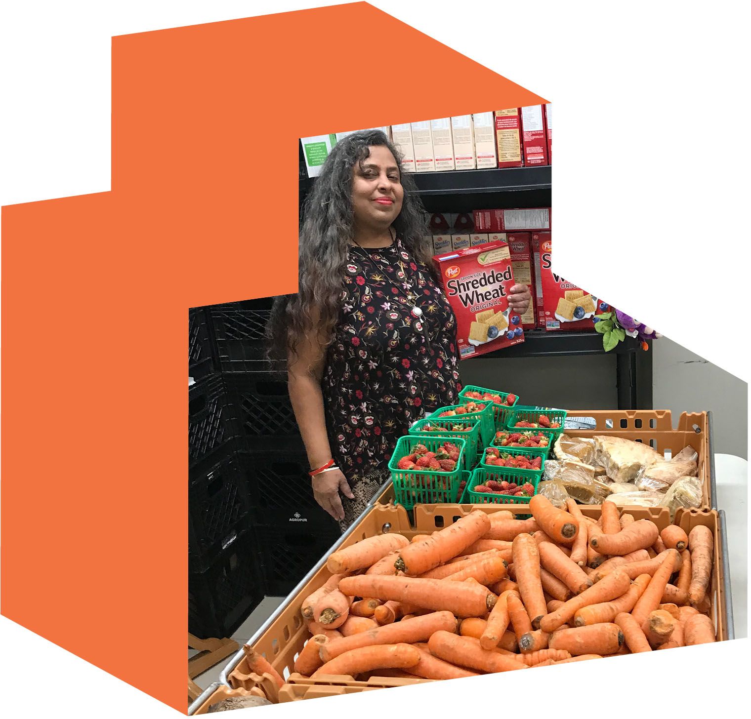 Indra Adjei standing behind tables full of produce and shelves of pantry items.