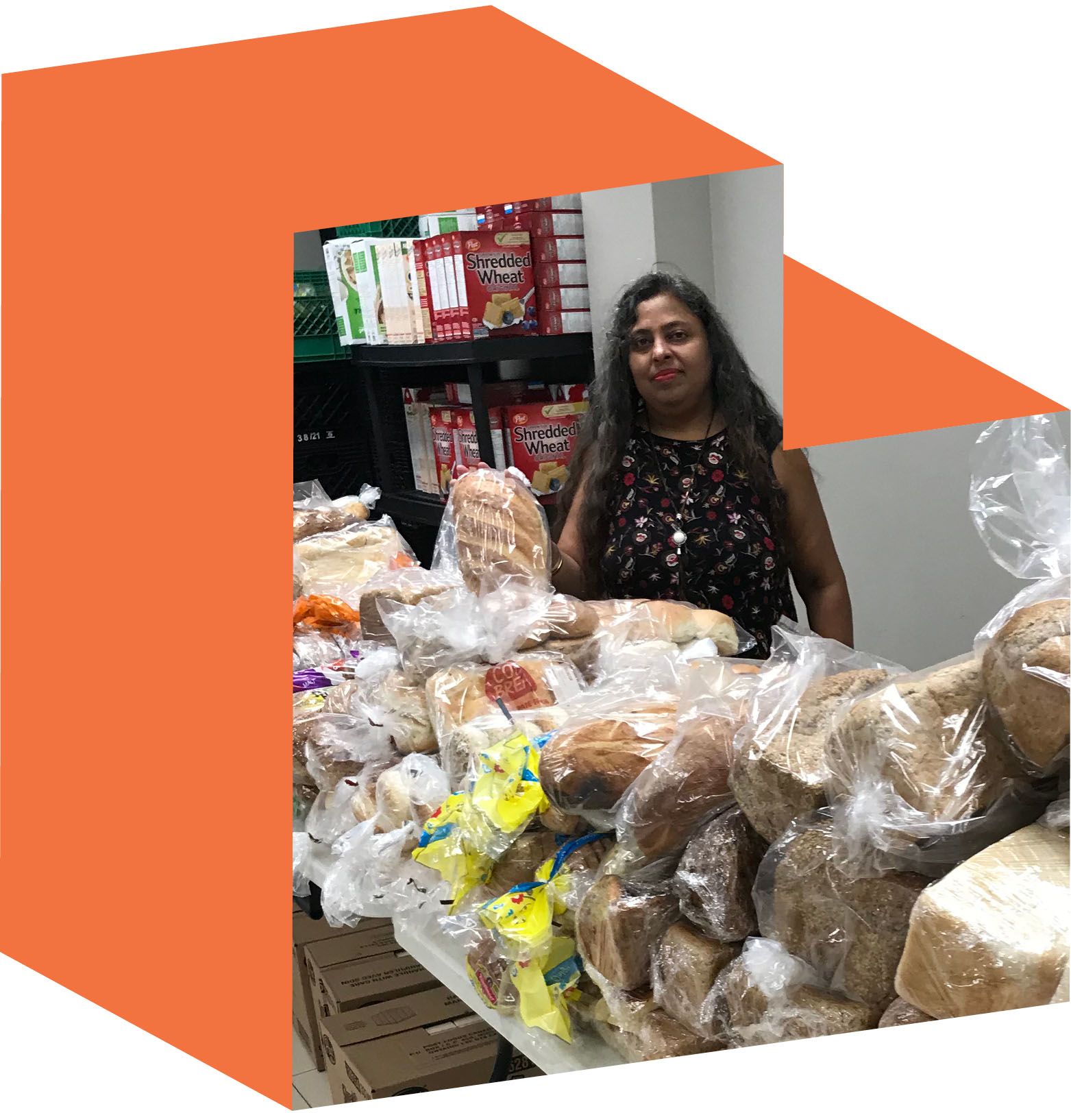 Indra Adjei standing in front of long tables piled high with bread.