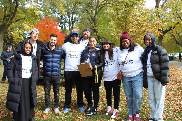 Group of people posing in a park, surrounded by fall leaves