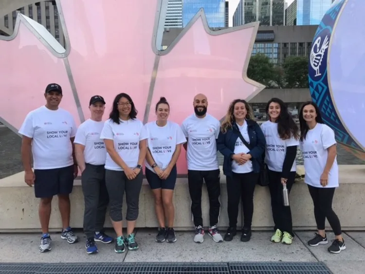 Group of people posing with T-shirts featuring the TCHC and United Way logos and the slogan "Show your local love"
