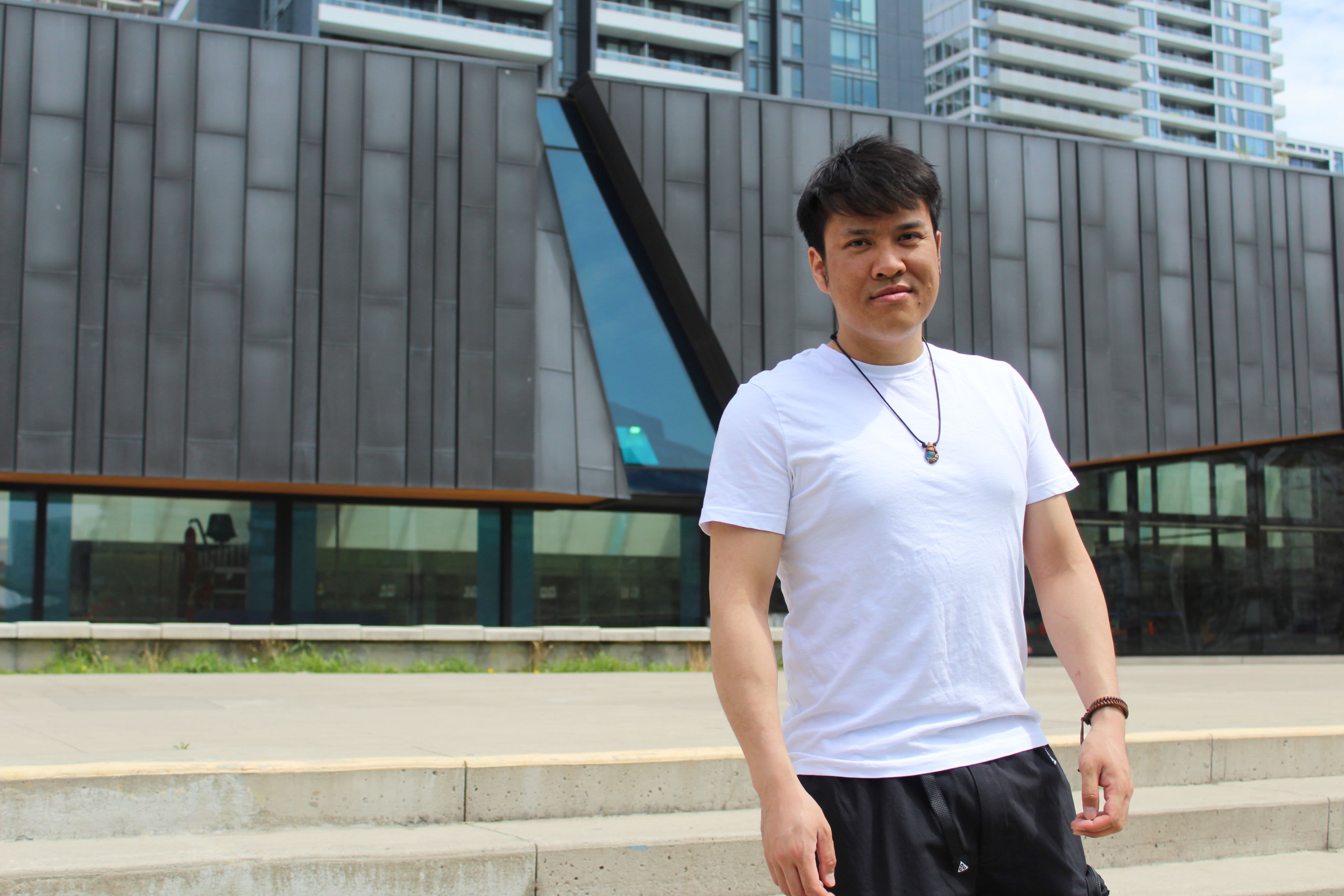 Person in T-shirt standing outside a building