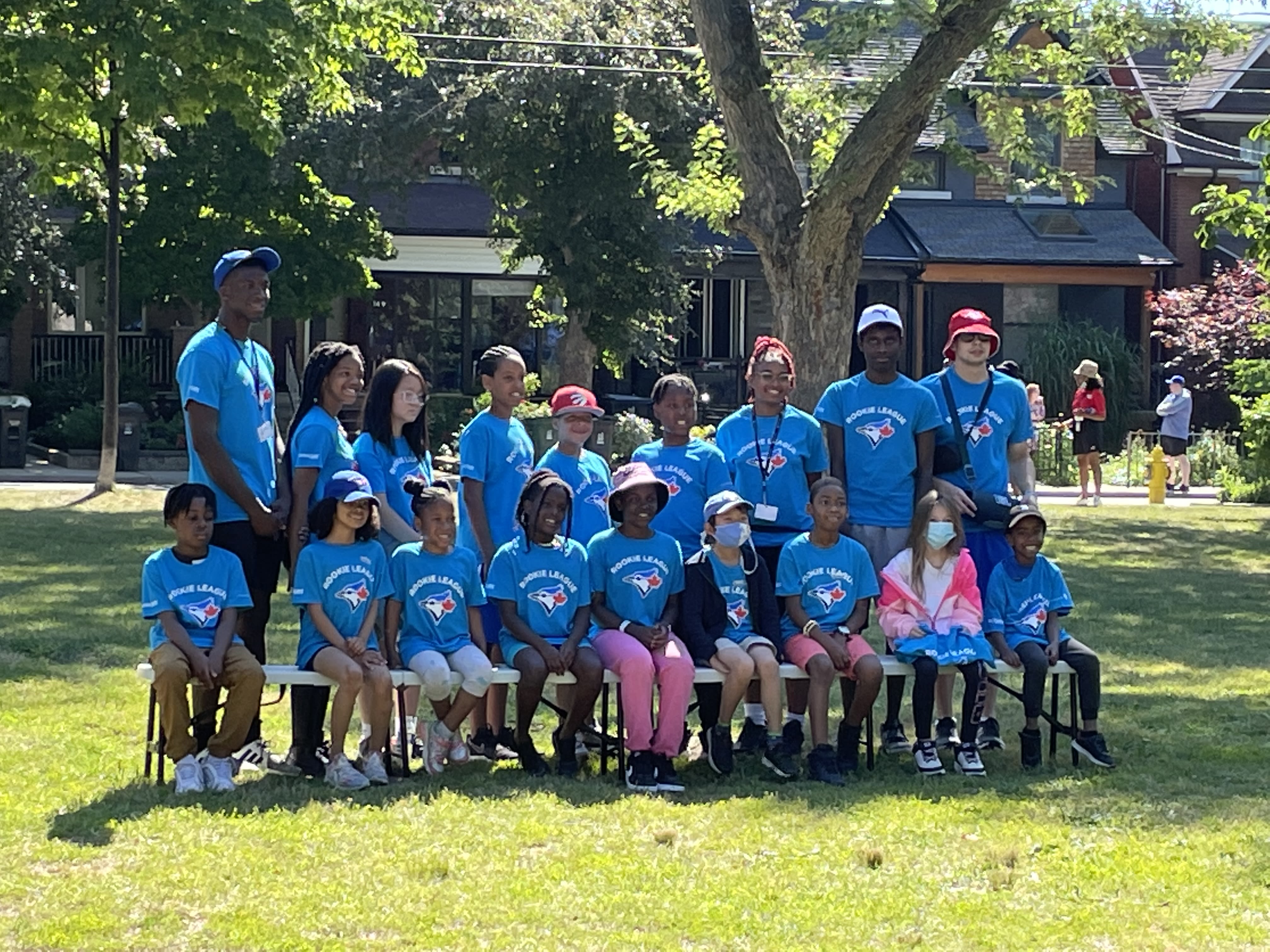 Participants and staff of Rookie League outside in a grassy area.