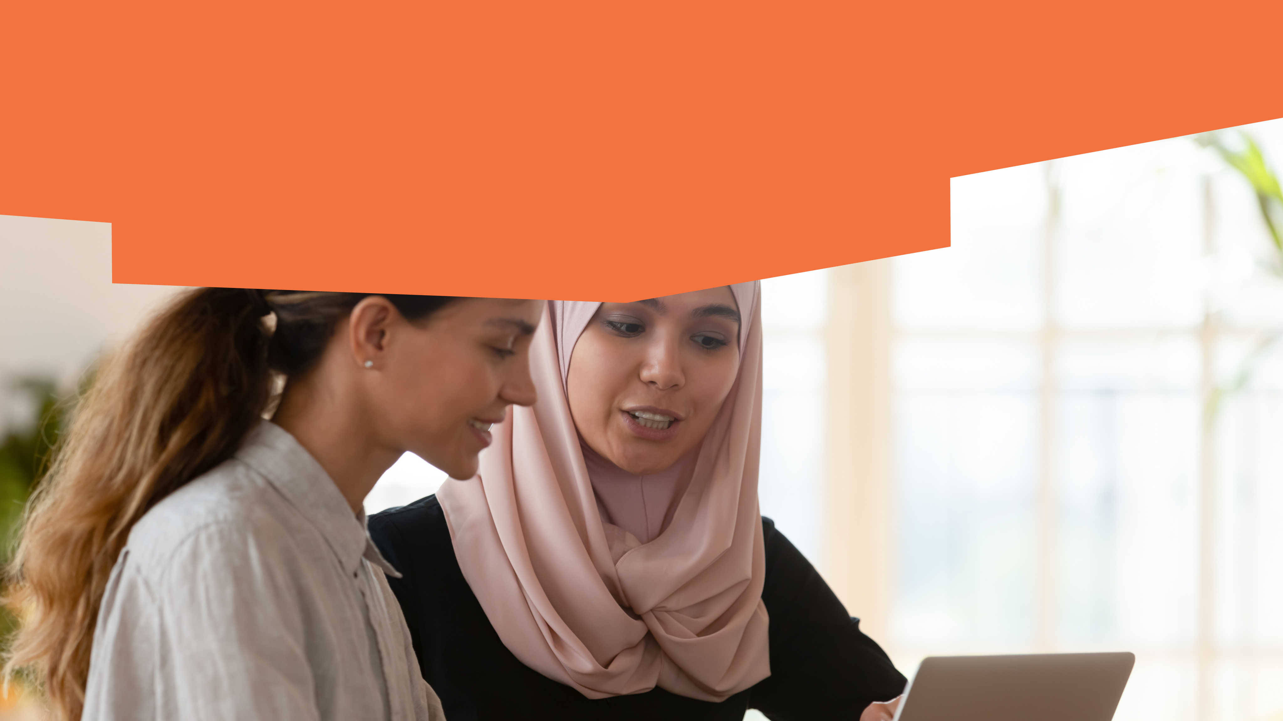 Two young people are talking and looking at a computer.