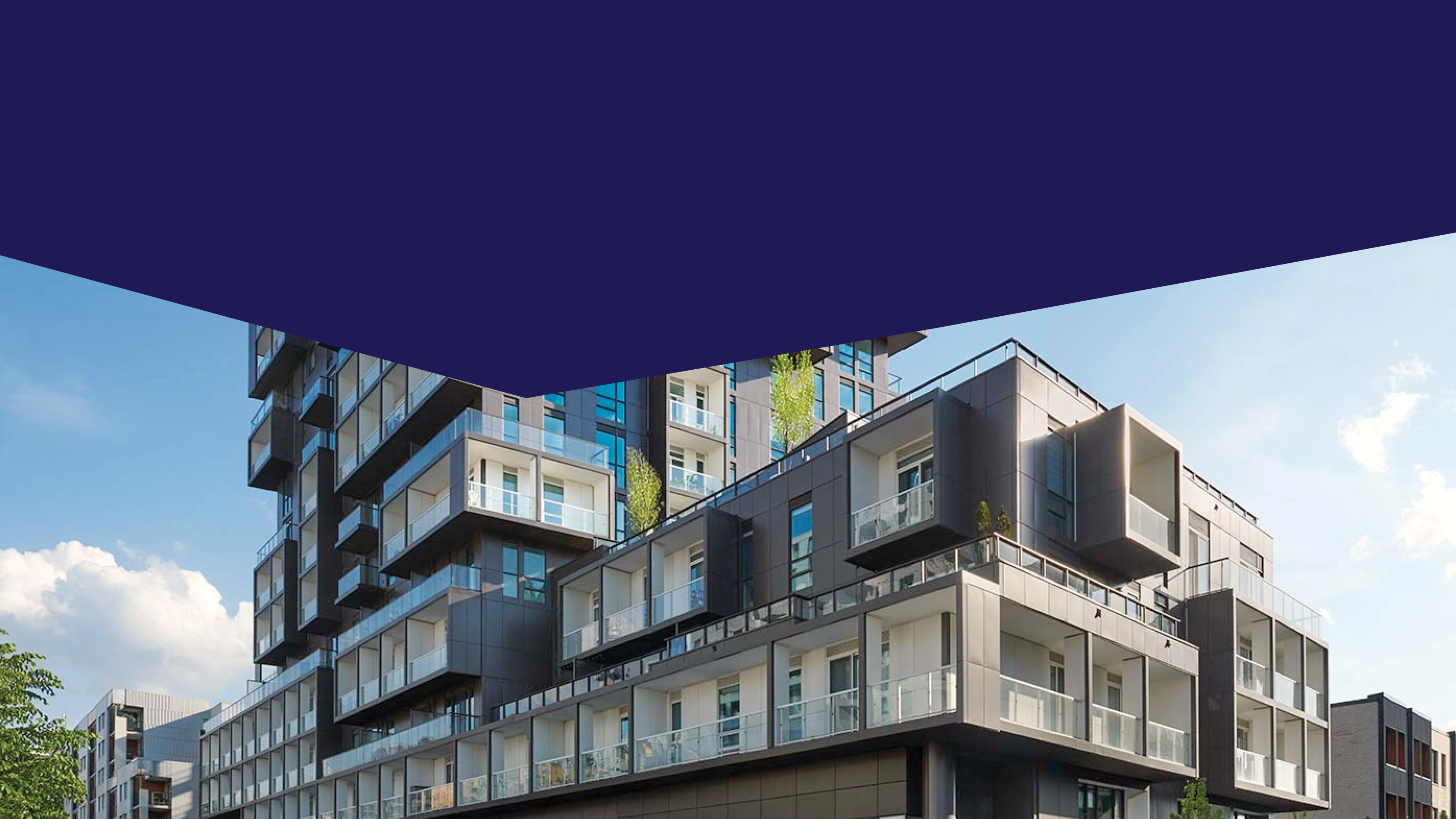 A modern apartment building with greenery on the rooftop in front of a blue sky.