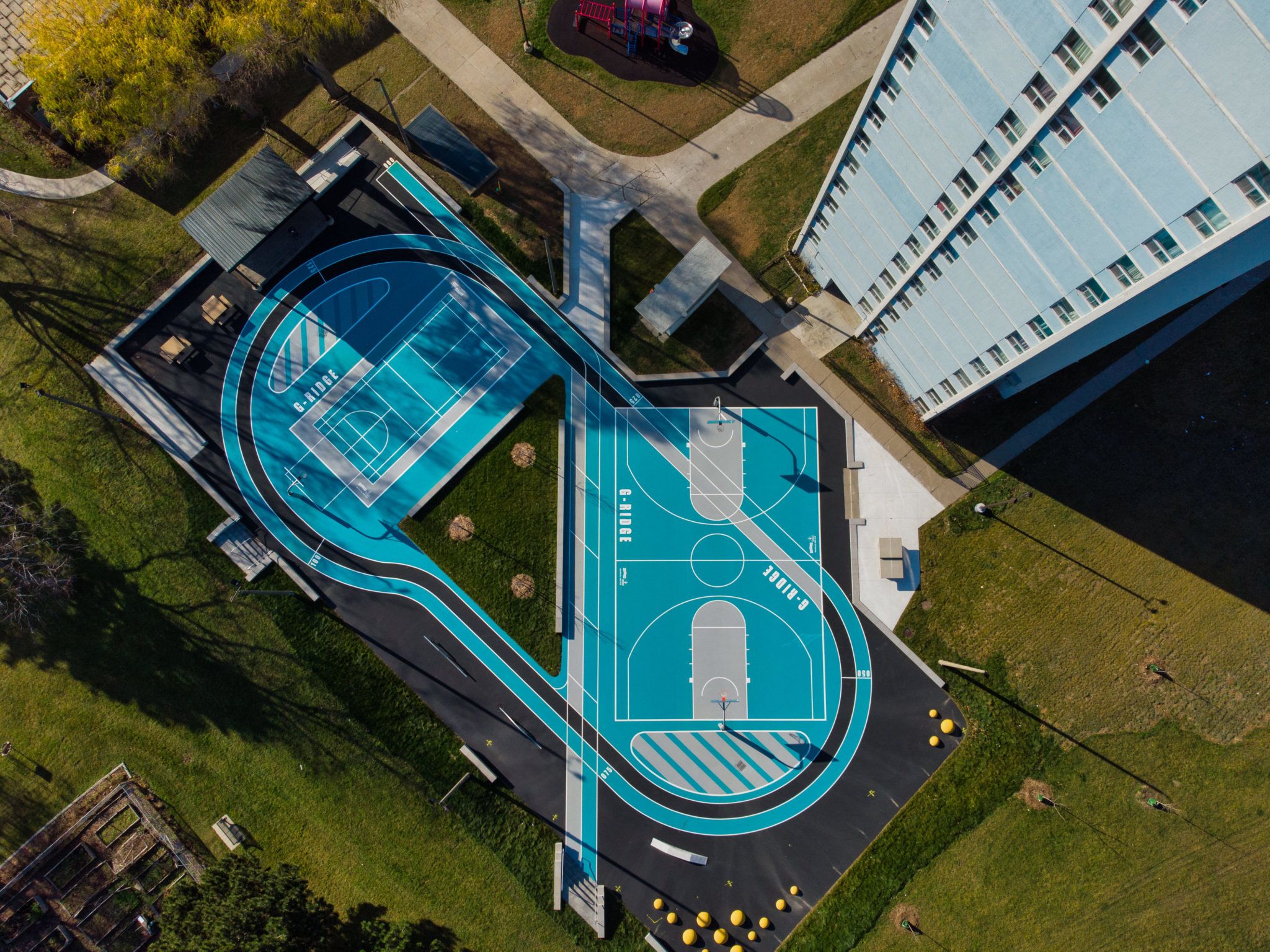 Bird's view shot of a blue basketball and tennis court at Gordon Ridge.