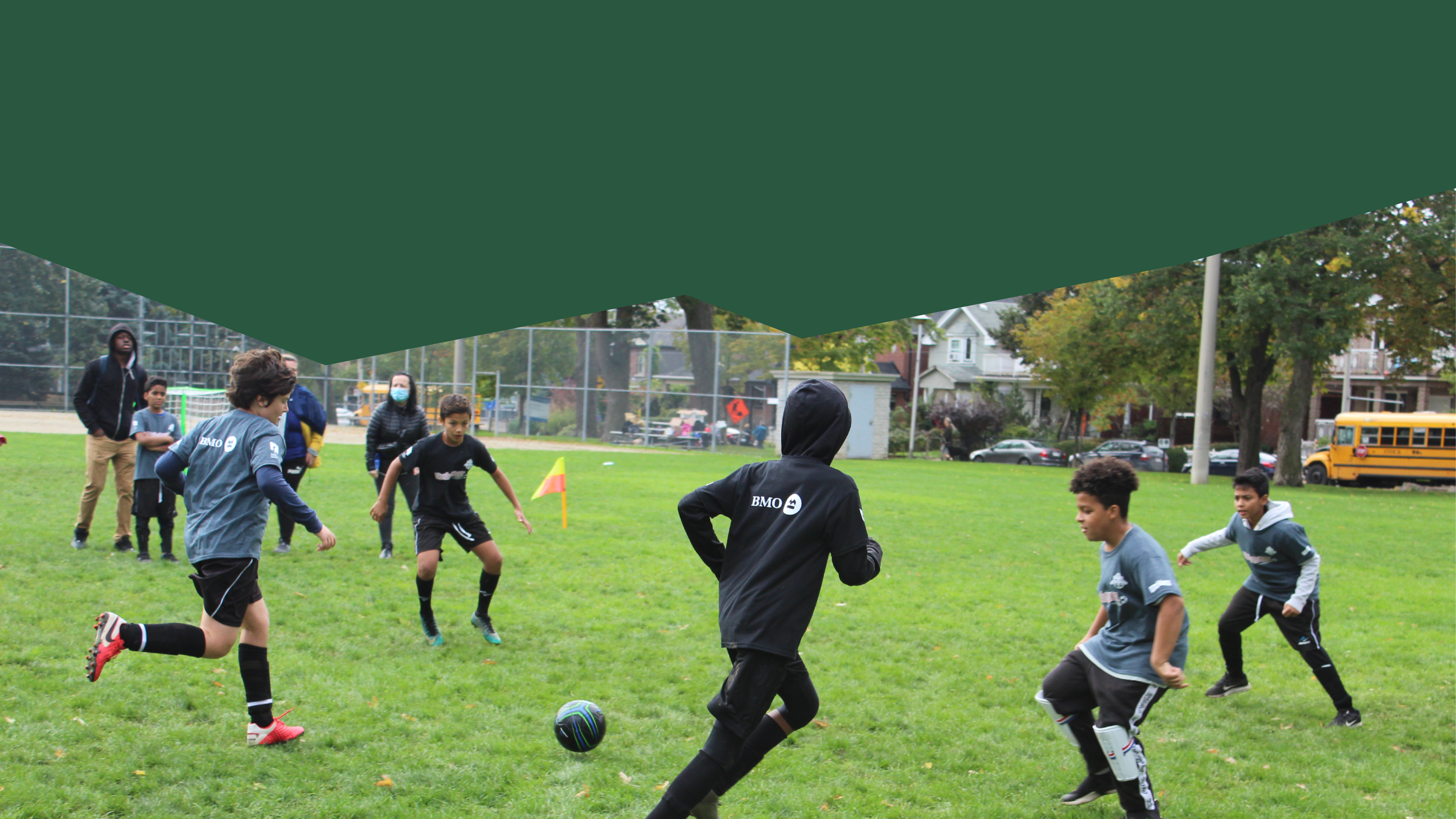 A group of children are playing soccer in a grassy field.