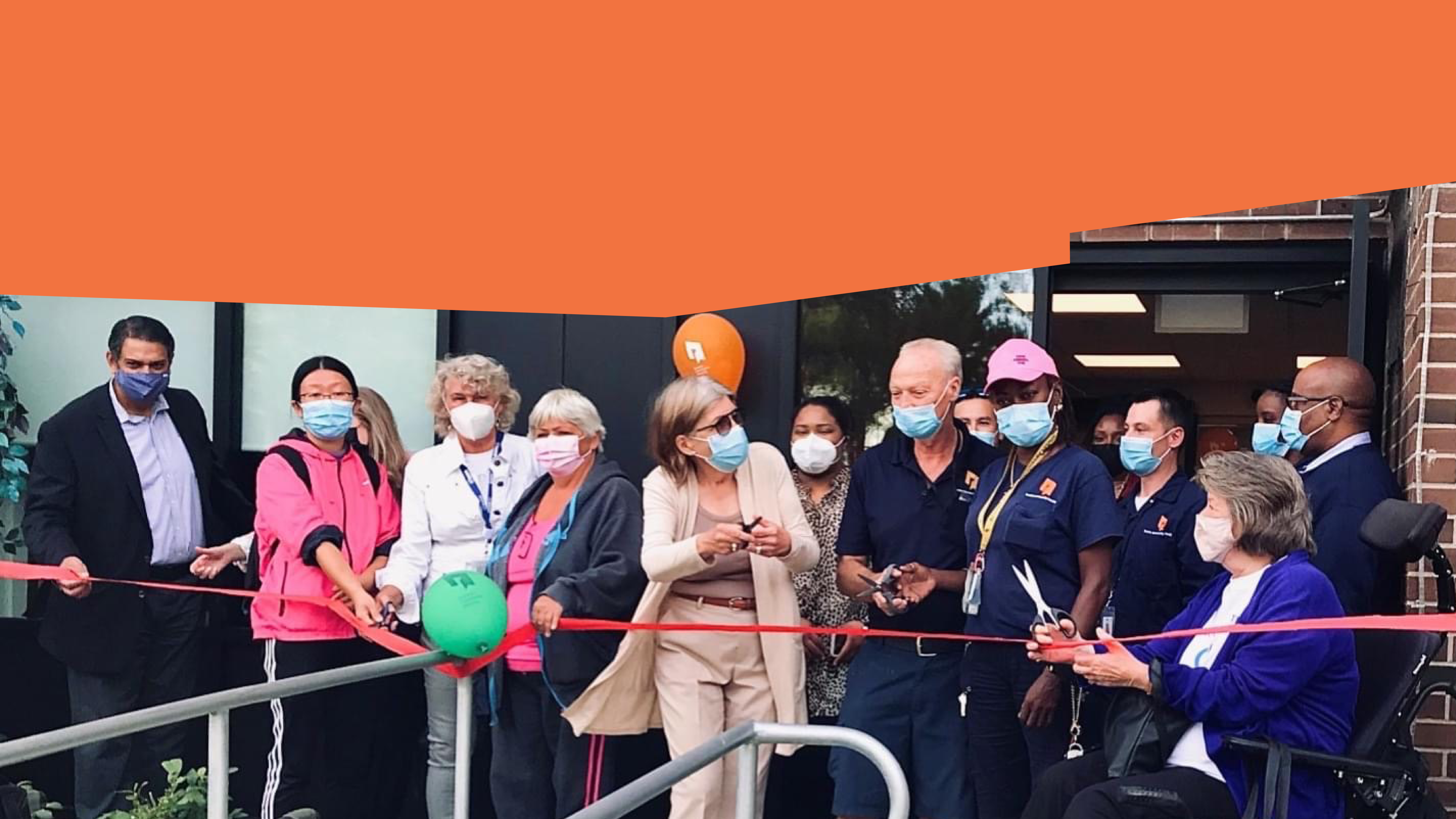 Sheila Penny, Jag Sharma, numerous TCHC staff and community members cutting a ribbon in front of a Tenant Service Hub.